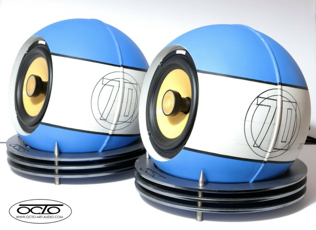 Paire d'enceintes acoustiques sphériques Octo 300 Édition Racing 70 posées sur supports à pointes de découplage.