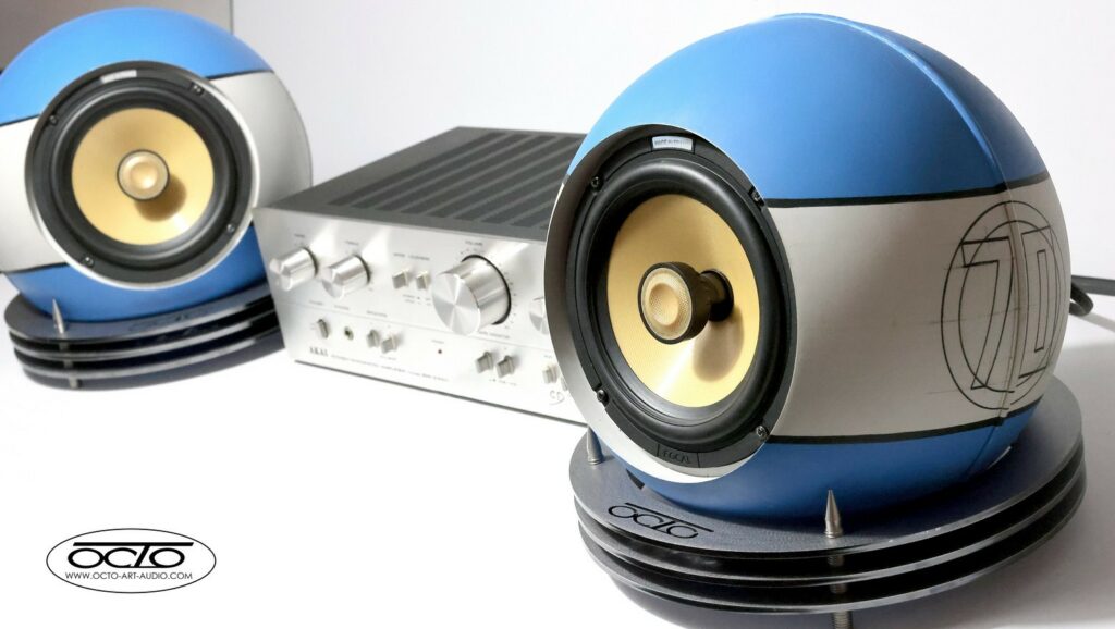 Paire d'enceintes acoustiques sphériques Octo 300 Édition Racing 70 entourant un amplificateur haute-fidélité vintage.