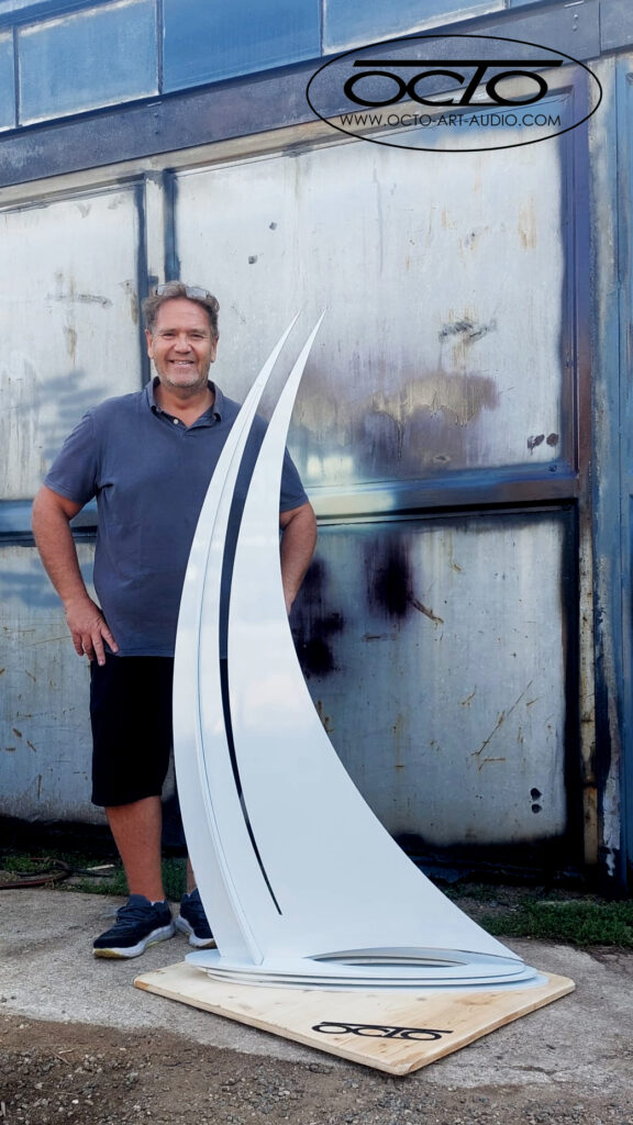 le créateur Arnaud Octo devant sa sculpture d un voilier élégant, magistrale et monumentale de 1,60m OCTO 1600s en acier et peinture blanche thermolaquage pour environnement intérieur et extérieur