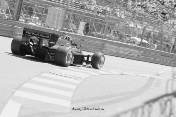 L'héritage de la vitesse : une Formule 1 John Player Special saisie dans l'esthétique intemporelle du noir et blanc. Photographie en noir et blanc d'une monoplace de Formule 1 historique John Player Special en pleine action sur un circuit, capturée par Arnaud d'Octo Art Audio.