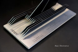 Vue géométrique et lignes fuyantes du Trophée de la Ville de Saint-Tropez, mettant en valeur le travail du bois et du métal signé Octo Art Audio. Vue en perspective du Trophée officiel SailGP de la Ville de Saint-Tropez, associant métal noir, plaque brossée et socle en bois gravé OCTO.