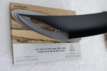 Vue rapprochée du Trophée de la Ville de Saint-Tropez 2025 – Édition Spéciale MAXI Yachts. Zoom sur le socle en bois avec logo gravé et plaque officielle du Trophée de la Ville de Saint-Tropez 2025 catégorie MAXI par Octo Art Audio.