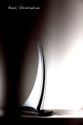 Jeu de lumière et lignes épurées : la sculpture d'art OCTO sous un angle studio. Sculpture design en acier et bois de style clair-obscur, trophée d'art moderne par Octo Art Audio.