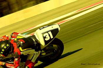Perspective immersive et vitesse pure pour la moto #31 de l'équipage Team Méraçous. Vue arrière d'une moto de course numéro 31 du Team Méraçous en plein virage et effet de filé sur le Circuit Paul Ricard.