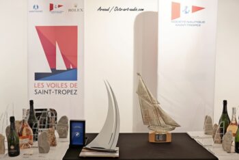 Le Trophée officiel de la Ville de Saint-Tropez (au premier plan) aux côtés du célèbre Trophée Rolex. Le Trophée de la Ville de Saint-Tropez en acier et bois exposé aux côtés du Trophée Rolex lors des Voiles de Saint-Tropez.