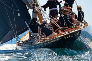 Flica II (K-14): Timeless elegance and mahogany reflections in the Mediterranean. Close-up of the stern of the 12mR yacht Flica II (K-14) with golden lettering, crew in action during the Toulon Provence Regatta 2026.