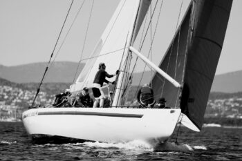 Lignes graphiques et contrastes intemporels. Le 12mJI South Australia (KA-8) en pleine action dans la baie de Hyères lors de l'Europa Cup 2026. Tirage d'art disponible en édition limitée. Photographie d'art en noir et blanc du voilier classique 12mJI South Australia KA-8 naviguant de trois-quarts avant avec son équipage en action, lors de l'Europa Cup 2026 à Hyères.