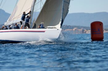 Précision millimétrée et tension à la marque. Le 12mJI South Australia (KA-8) en plein passage de bouée dans la baie de Hyères lors de l'Europa Cup 2026. Tirage d'art disponible sur commande. Photographie d'action en mer du voilier de course 12mJI South Australia KA-8 frôlant une bouée de régate orange TPM lors de l'Europa Cup 2026 à Hyères. Vue rasante sur la coque blanche fendant les vagues et l'équipage en pleine manœuvre à l'avant.